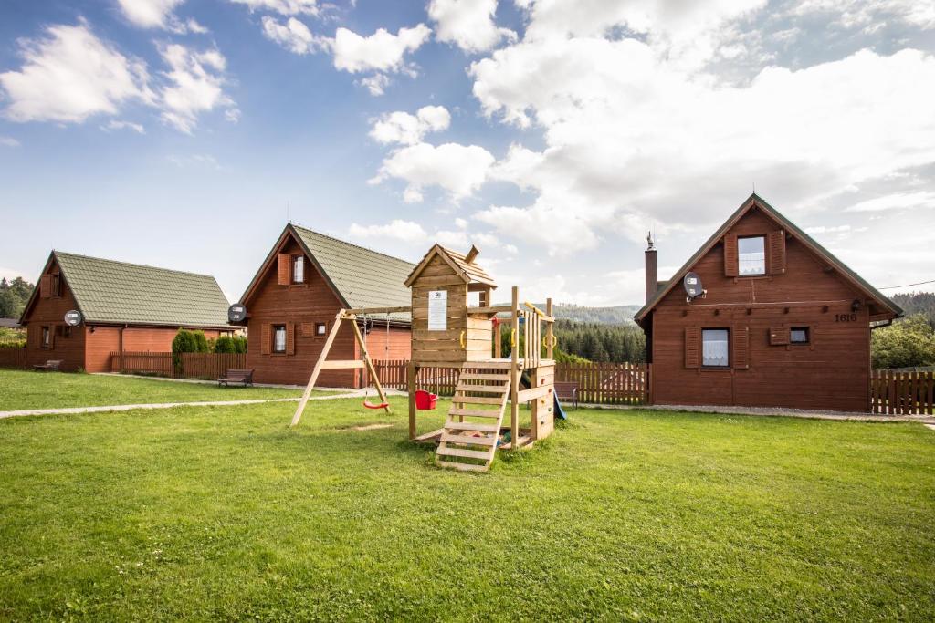 a playground in a yard in front of a house at Domki Krótki Szpic in Istebna