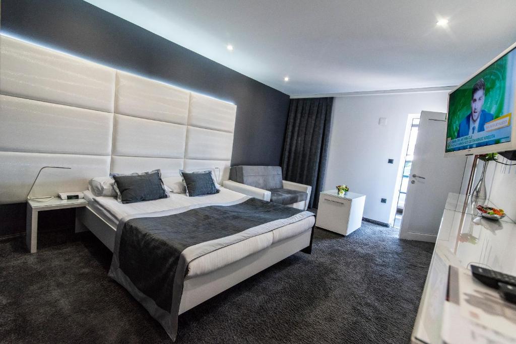 a hotel room with a bed and a television at Hotel Cool Zagreb Airport in Velika Gorica