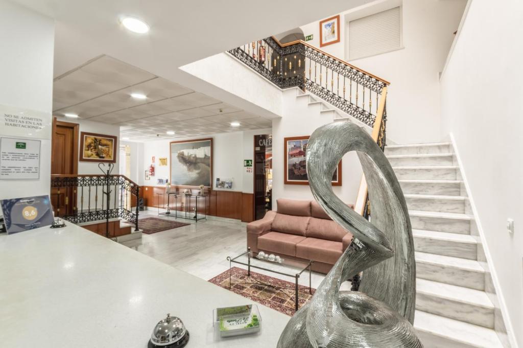 salon ze schodami i metalową rzeźbą w obiekcie Hotel La Parrita w mieście Rota
