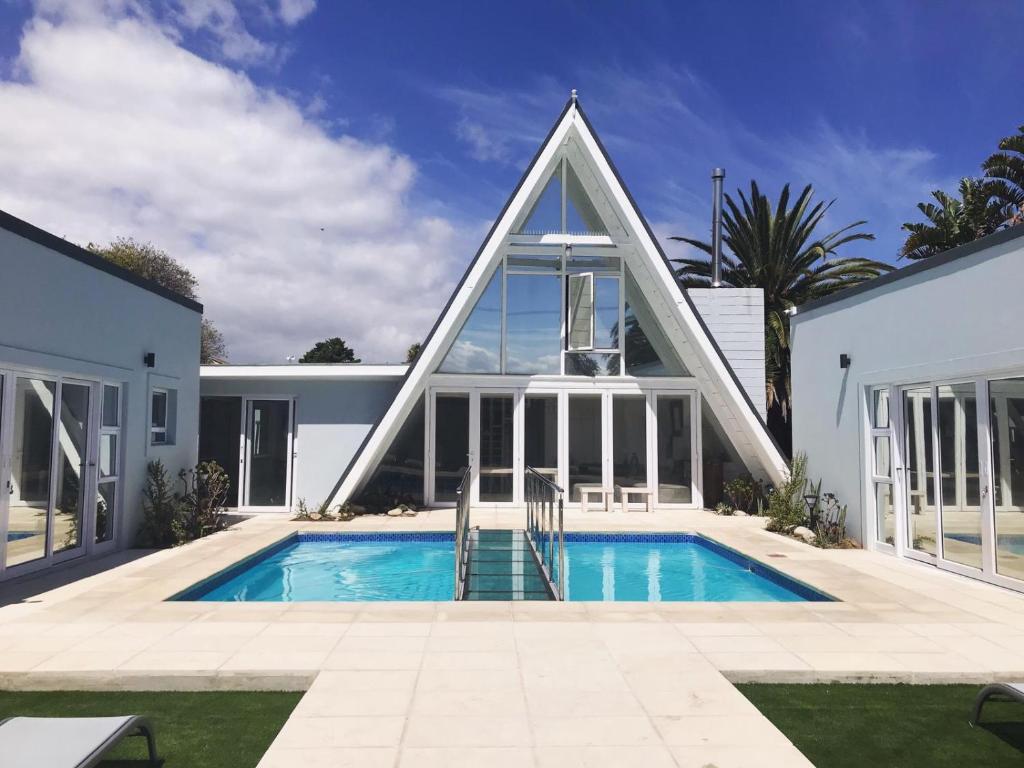 una casa con piscina a forma di piramide di SALT Boutique Guesthouse a Bloubergstrand