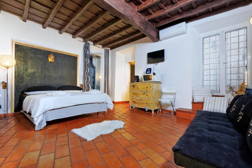 a bedroom with a large bed and a couch at 3Chic Maison Colosseo in Rome