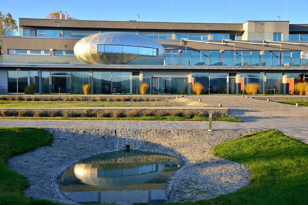 a building with a pond in front of a building at Antonie Hotel****superior in Frýdlant