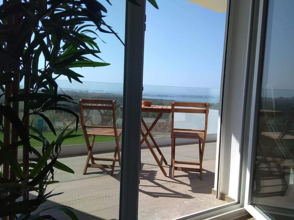 uma mesa e cadeiras numa varanda com vista em Marlin House III em Peniche