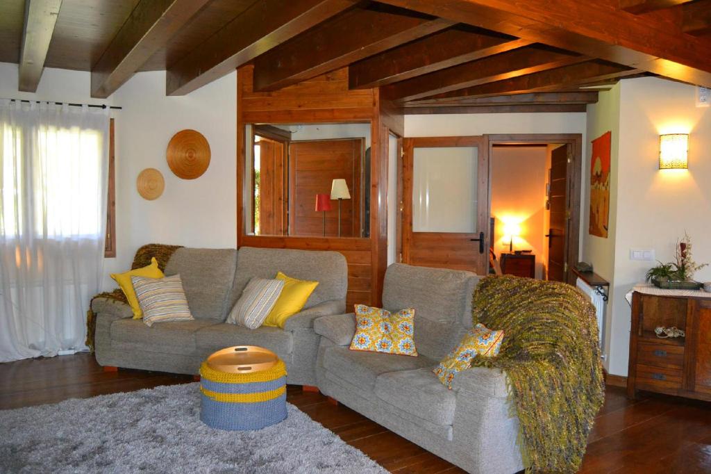 a living room with a couch and a ottoman at Preciosa planta baja con piscina in Caixáns