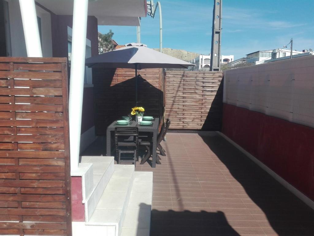 un patio con una mesa y una sombrilla en Lisbon Beach Apartments 1, en Costa da Caparica