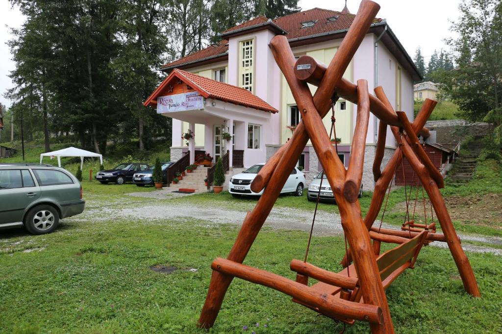 une balançoire en bois devant une maison dans l'établissement Pension Rose-Trandafirul, à Borsec