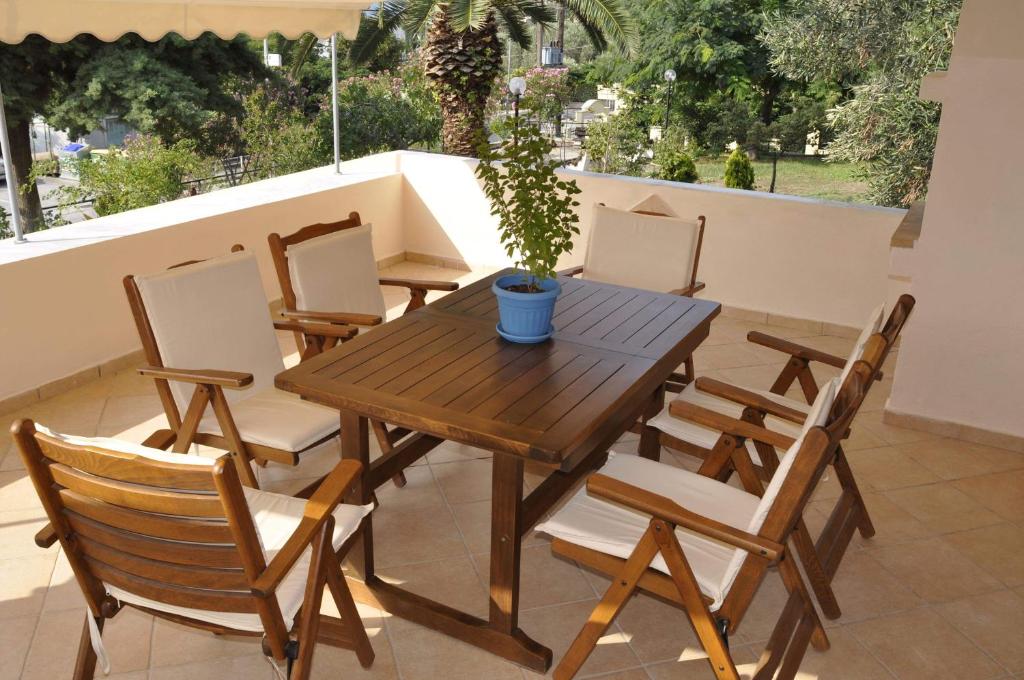 a wooden table and chairs with a potted plant on a patio at Feel free in Paleo Tsifliki