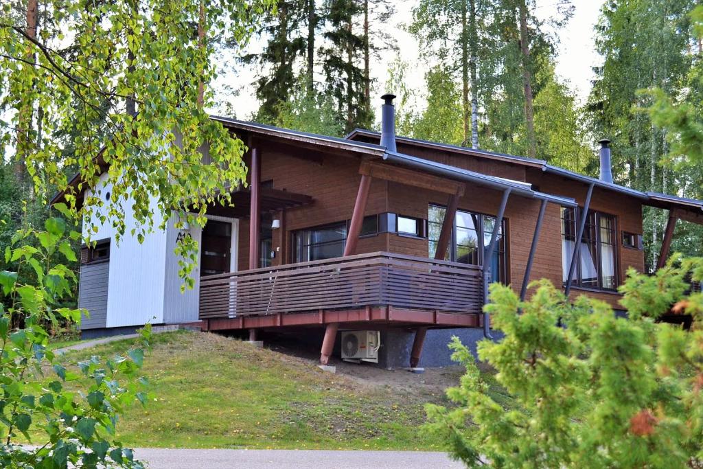 a house with a large deck in the woods at Saimaa Style Spa Chalet in Imatra