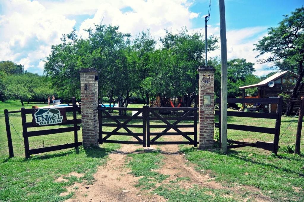 een houten poort met een bord erop in een veld bij Enkel Cabañas in José de la Quintana
