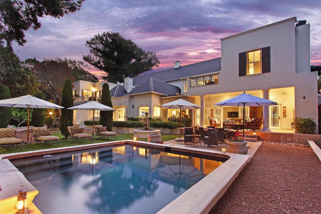 a house with a swimming pool in front of it at Stellenbosch Manor in Stellenbosch