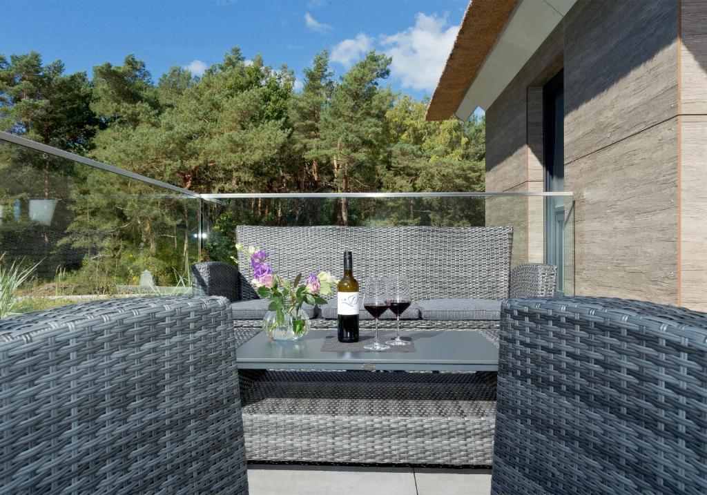 a patio with a table with a bottle of wine at Düne 74 in Karlshagen