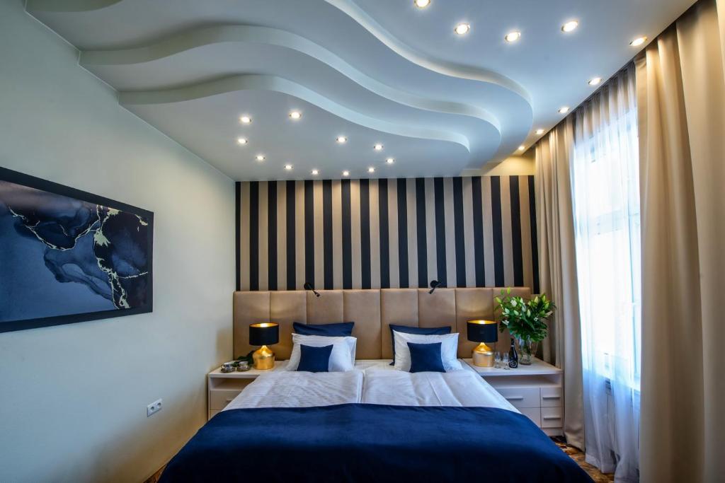 um quarto com uma cama grande e lençóis azuis em Hotel Royal em Gliwice