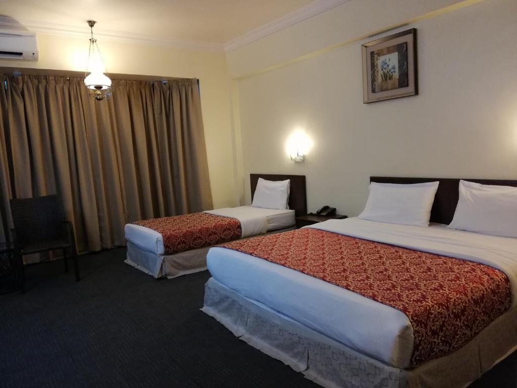 a hotel room with two beds in a room at Hotel Damai in Parit Buntar