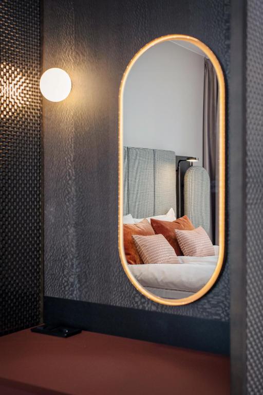 a mirror in a room with a bed in it at Clarion Hotel Oslo in Oslo
