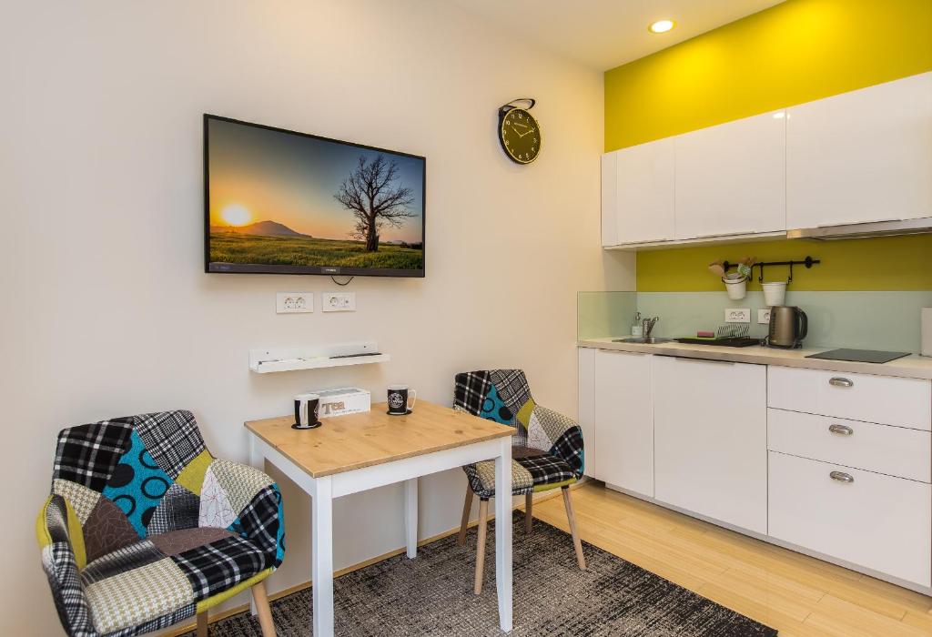 kuchnia ze stołem i krzesłami w pokoju w obiekcie MirÓ Studio Apartments Zagreb w Zagrzebiu