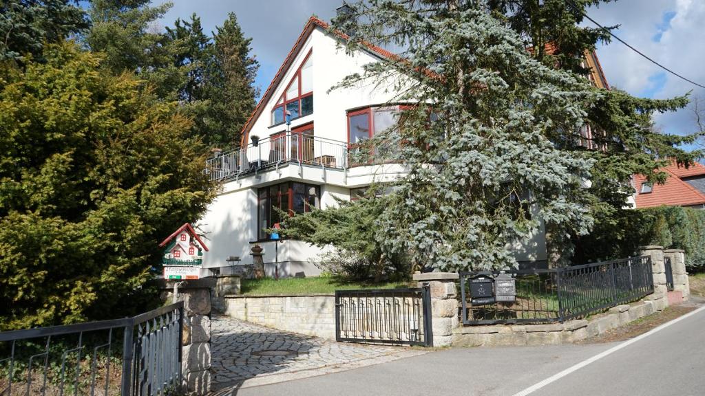 een wit huis met een hek ervoor bij Ferienwohnung Frenzel in Kurort Gohrisch