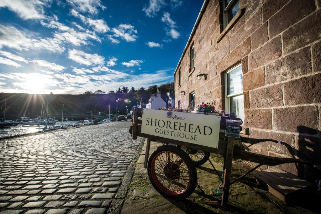 a sign on a bike parked next to a brick building at Shorehead Guest House in Stonehaven