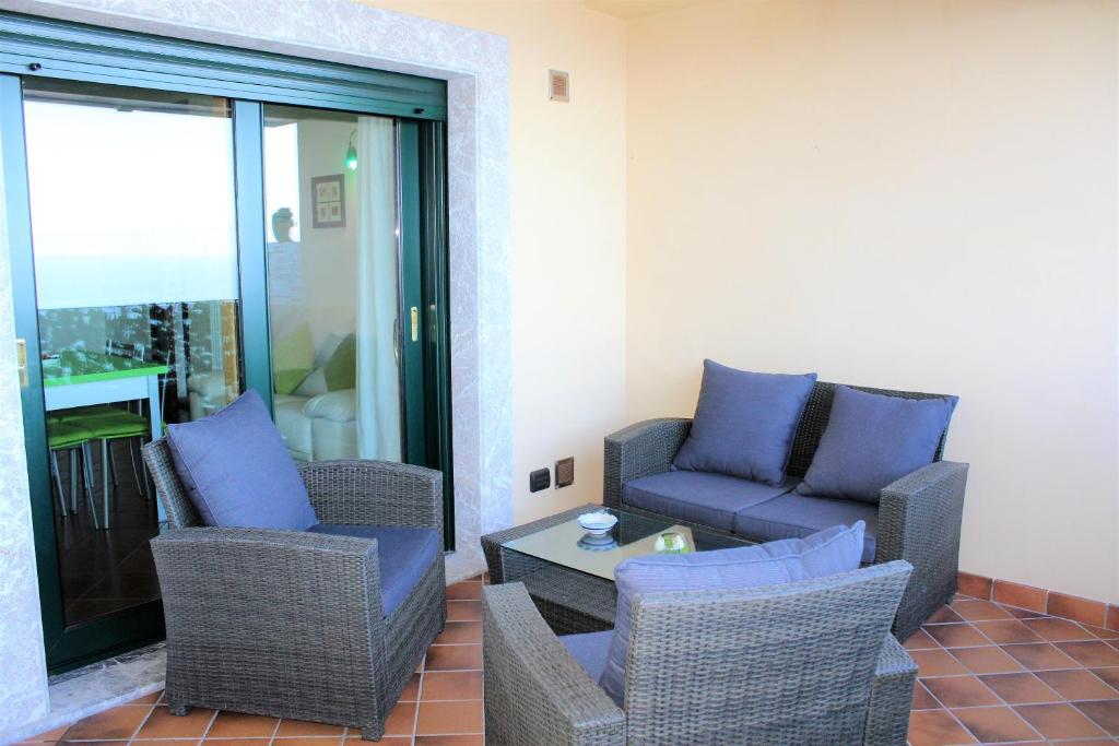 a living room with chairs and a couch and a table at Villa Sofia in Taormina