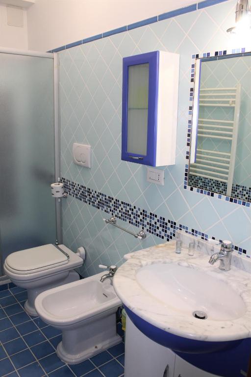 a bathroom with a sink and a toilet and a mirror at Villa Sofia in Taormina