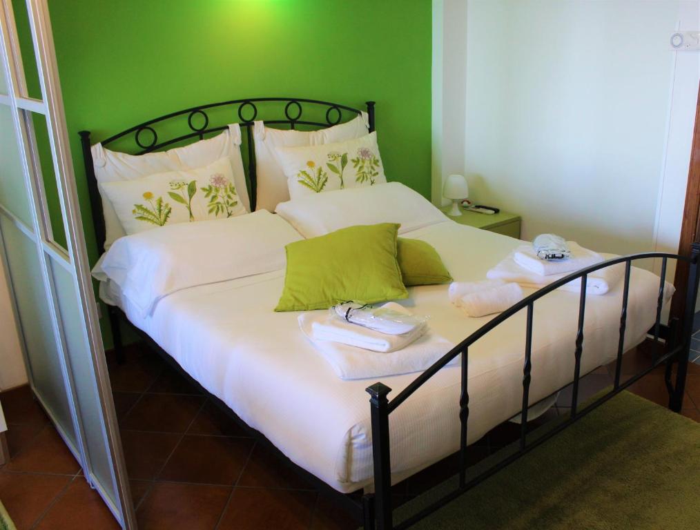 a bedroom with a bed with white sheets and green walls at Villa Sofia in Taormina