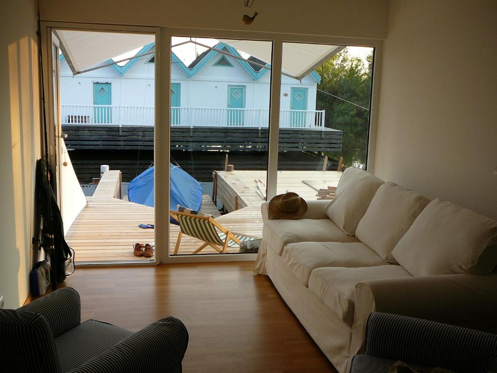 ein Wohnzimmer mit einem Sofa und Blick auf eine Terrasse in der Unterkunft Bootshaus am See in Neusiedl am See