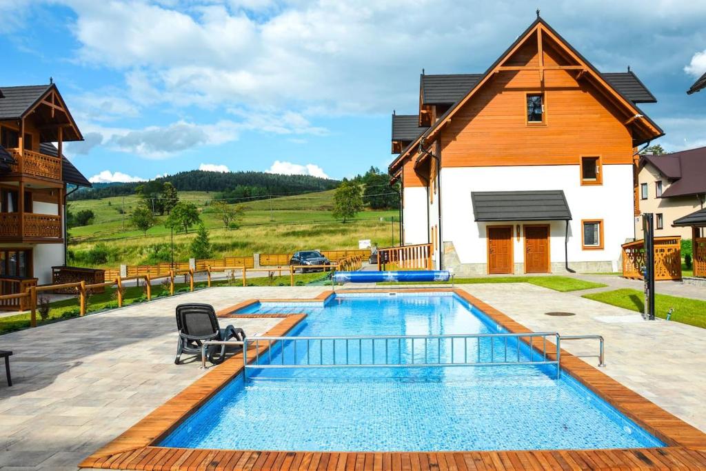 a swimming pool in the backyard of a home with a house at Przystań Góralska in Szczawnica