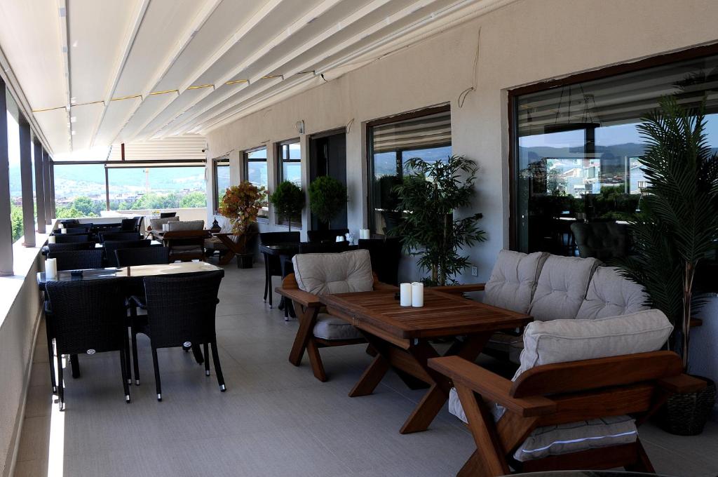 a restaurant with tables and couches and tables and chairs at Casa Grande Otel in Biga