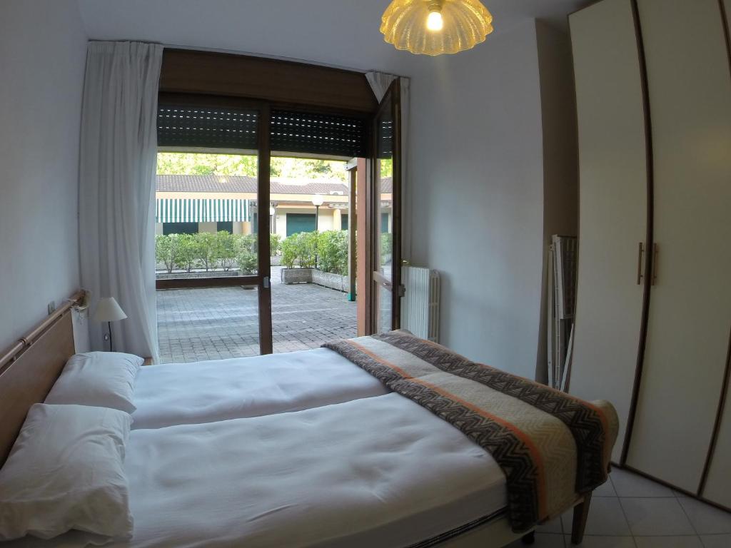 1 dormitorio con cama y ventana grande en Corallo Cavallino en Cavallino-Treporti