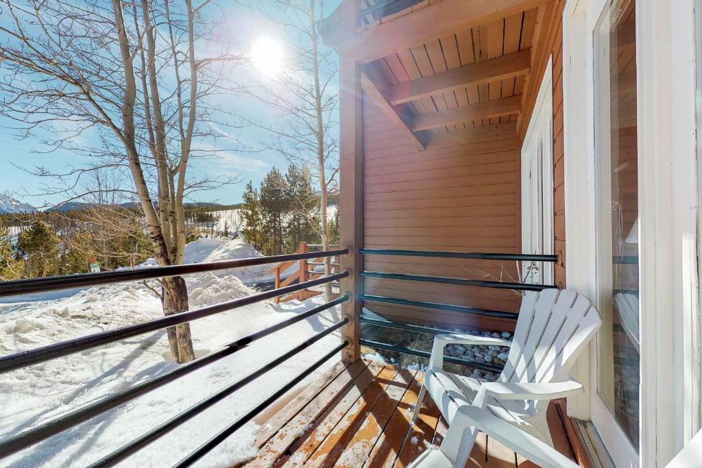een houten veranda met een bank en sneeuw erop bij Timber Ridge Retreat in Silverthorne
