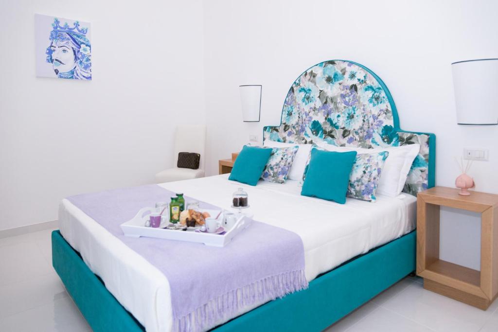 a bedroom with a blue and white bed with a tray of food on it at Sorrento Stylish Rooms in Sorrento