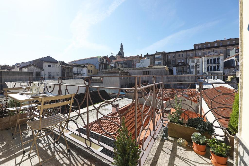 balcón con mesa, sillas y plantas en FLH Almada Cozy Apartment with View, en Oporto