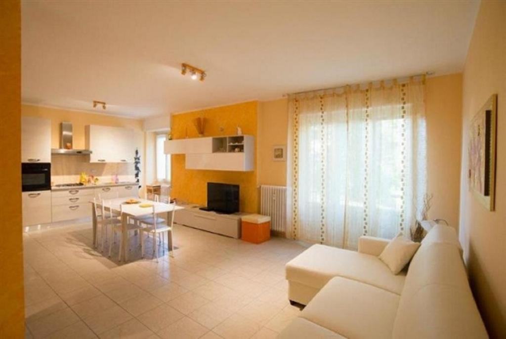 un soggiorno con divano bianco e una cucina di Vittorio Veneto Apartments a Sarnico