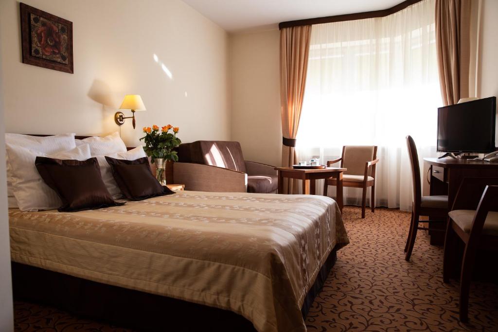 a hotel room with a bed and a desk at Hotel Panorama in Ostrowiec Świętokrzyski