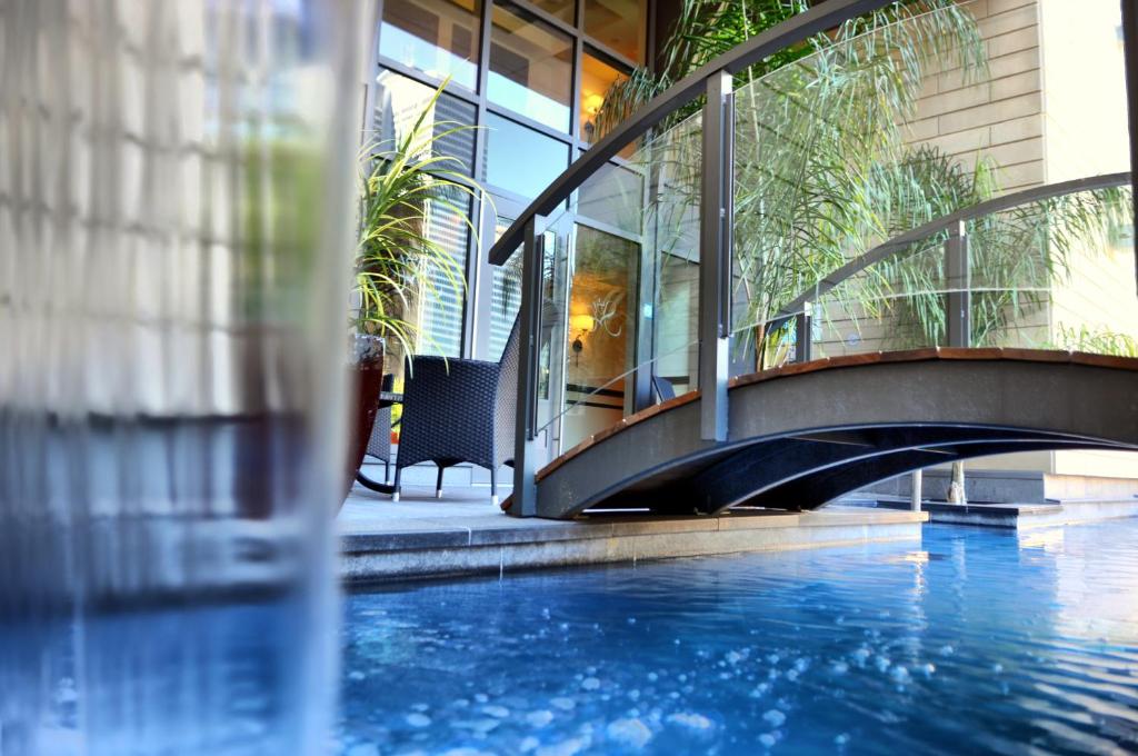 a building with a swimming pool and a bridge at Le St-Martin Hotel Centre-ville – Hotel Particulier in Montreal