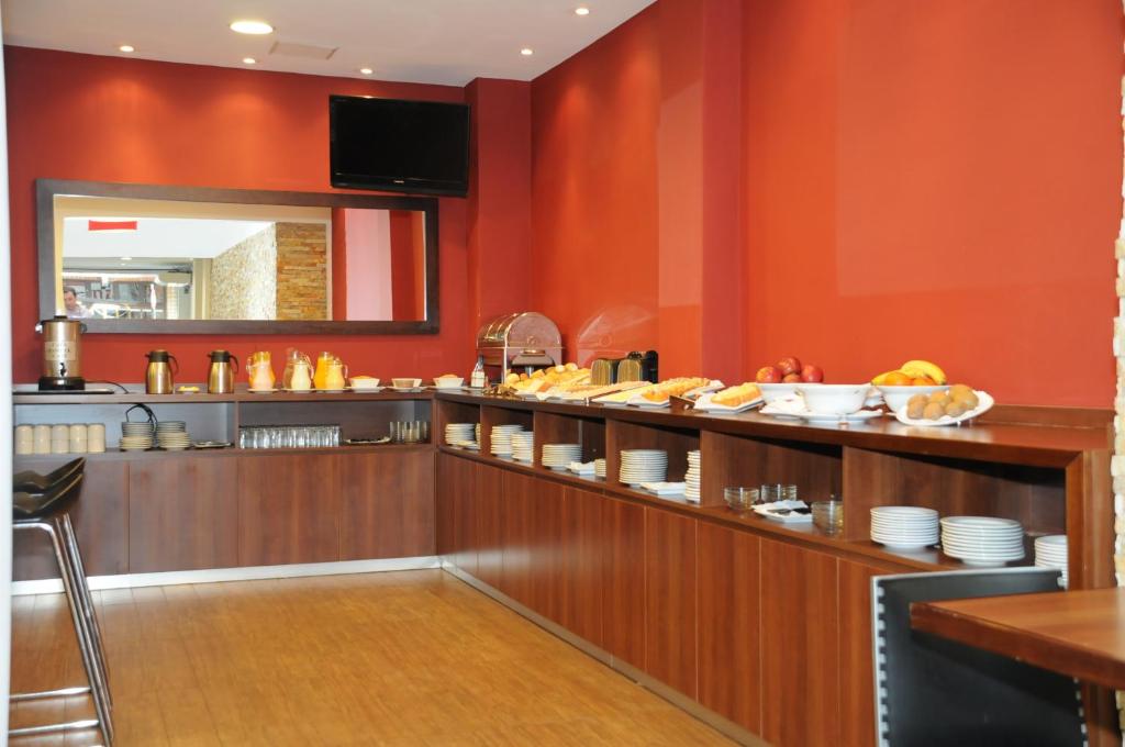 a restaurant with red walls and a counter with food at Hotel California in Montevideo