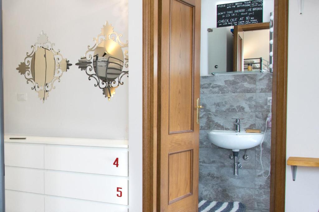 un baño con lavabo y espejo en Posada Verona Hostel, en Verona