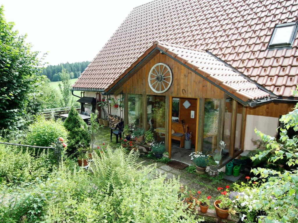 ein Haus mit einem großen Fenster in einem Garten in der Unterkunft Hornihäusle in Aufʼm Bühl