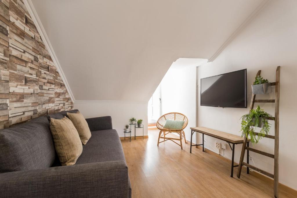 a living room with a couch and a tv at Rato Cozy 3BR w/balcony - by LU Holidays in Lisbon