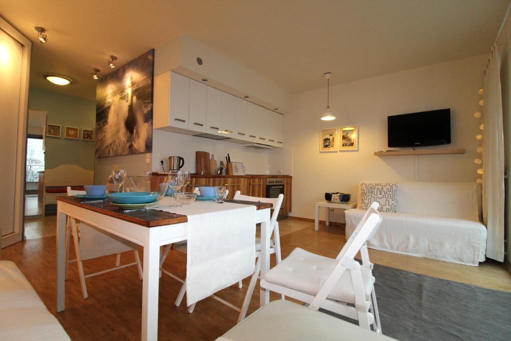 kuchnia i salon ze stołem i krzesłami w obiekcie Apartament z widokiem w mieście Puck