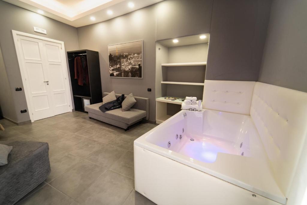 a large bathroom with a tub and a couch at Royal Art H Duomo - Napoli Centro, by ClaPa Group in Naples