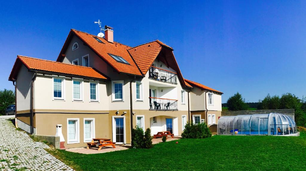 una casa con techo naranja en un patio verde en Lipno Apartmany Frymburk II., en Frymburk