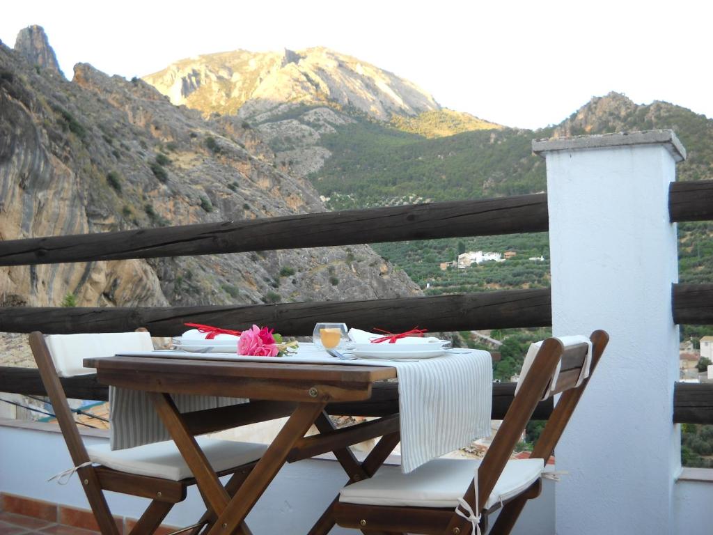 een tafel en stoelen op een balkon met een berg bij Casa Rural El Balcón de Cazorla in Tiscar