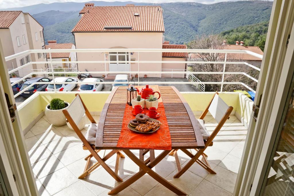 a table with a plate of food on a balcony at Josephine Rabac in Rabac