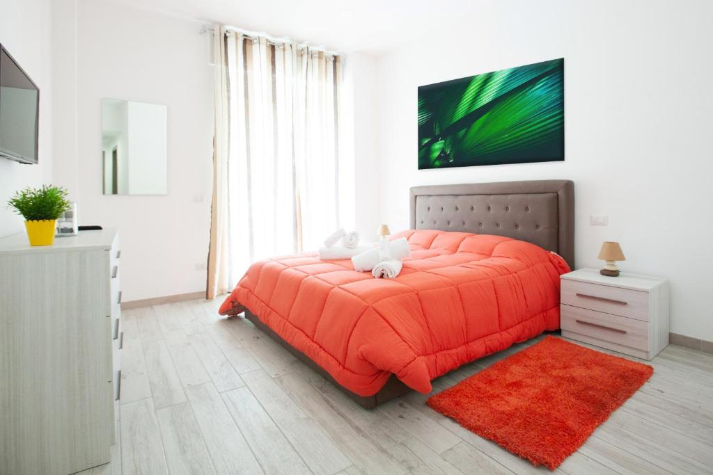 a bedroom with a bed with an orange comforter at New Tiburtina in Rome