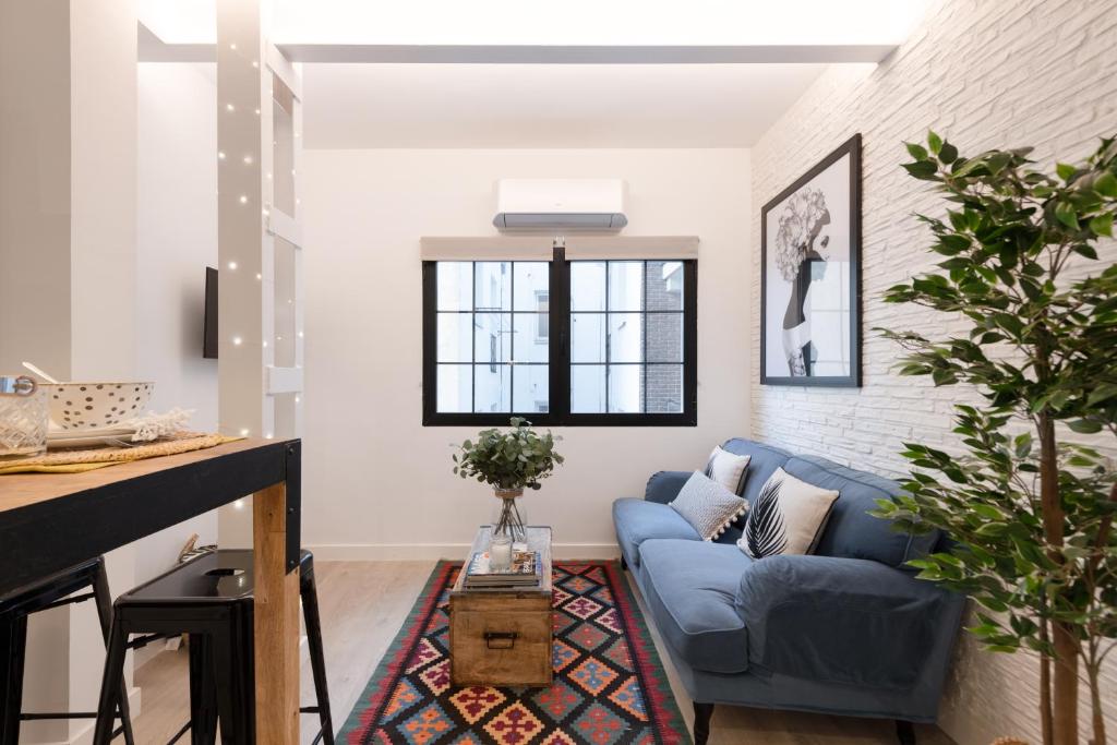 sala de estar con sofá azul en Cozy Apartment Salamanca Neighborhood en Madrid