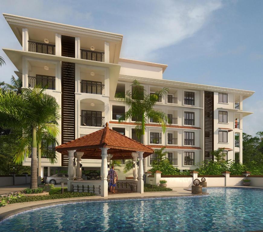 ein Hotel mit einem Pool vor einem Gebäude in der Unterkunft Casa Legend Suites Candolim Goa in Candolim