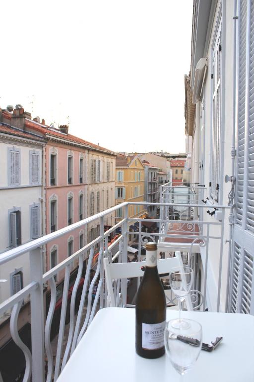 - une bouteille de vin assise sur une table sur un balcon dans l'établissement Charming apartment in the heart of Cannes, à Cannes