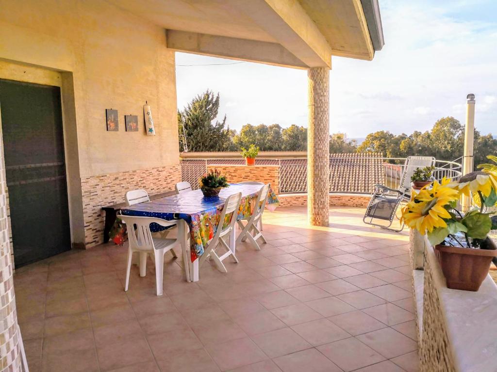 eine Veranda mit einem Tisch und Stühlen auf einer Terrasse in der Unterkunft Paradise House in Alcamo Marina