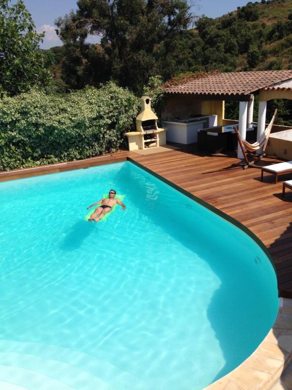 a person swimming in a large blue swimming pool at Villa SERENA in Sarrola-Carcopino