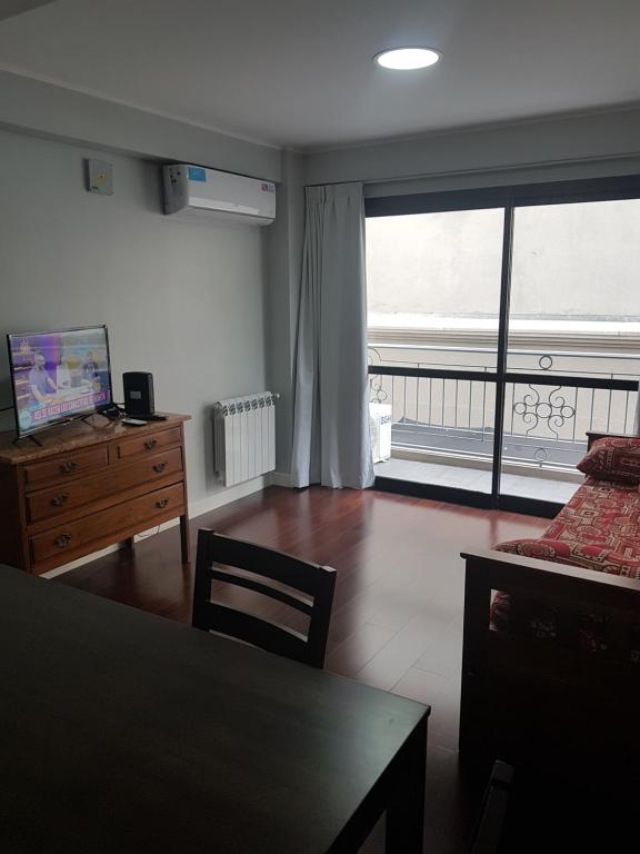 een woonkamer met een tafel en een groot raam bij Leguizamon suite con cochera in Salta